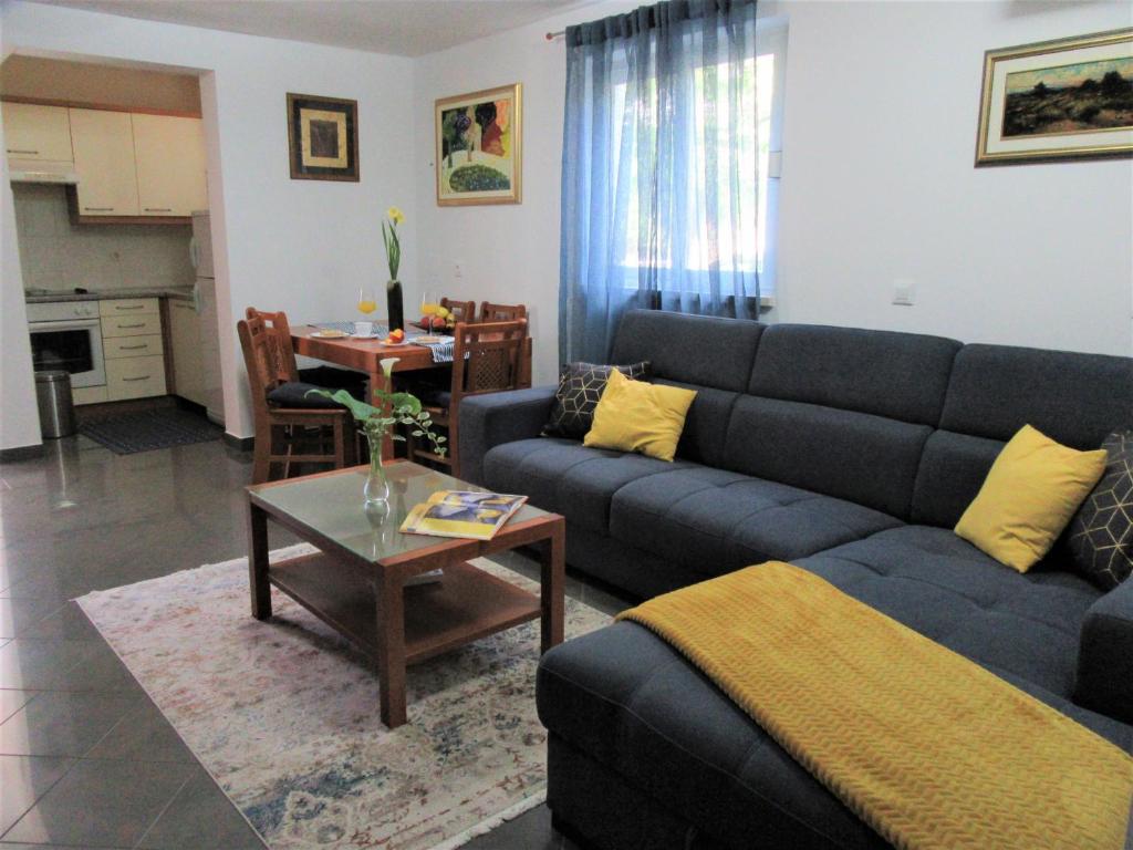 een woonkamer met een blauwe bank en een tafel bij Apartment Andrea in Orebić