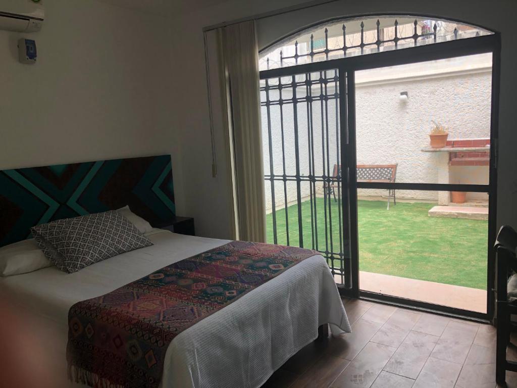 a bedroom with a bed and a large window at Casa Nova! PRIVATE BATHROOM AND ROOM in Cancún