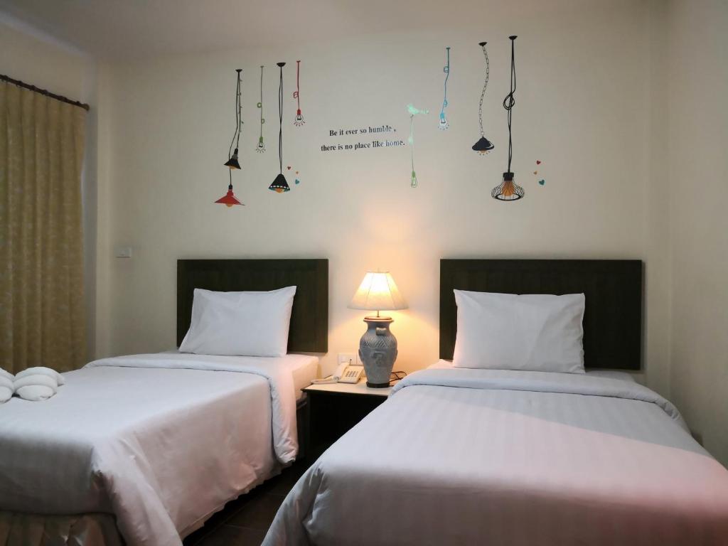 Postel nebo postele na pokoji v ubytování Baan Suksiri Hotel