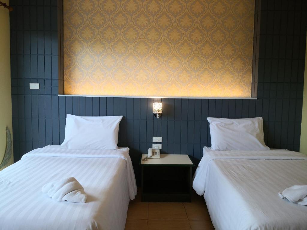 Postel nebo postele na pokoji v ubytování Baan Suksiri Hotel