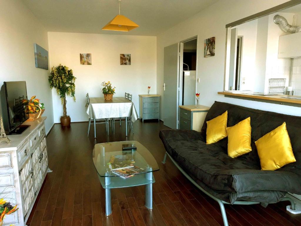 sala de estar con sofá y mesa en zizouk Bordeaux, en Mérignac