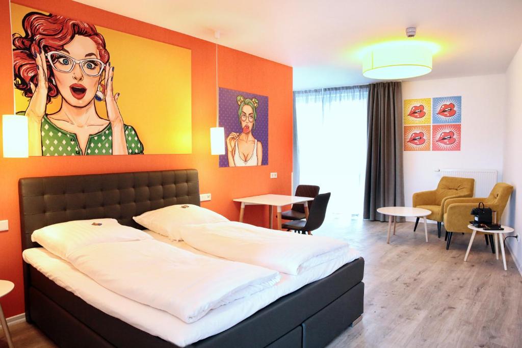 a bedroom with a bed with a painting of a woman at Hotel Apart GO25 in Herford