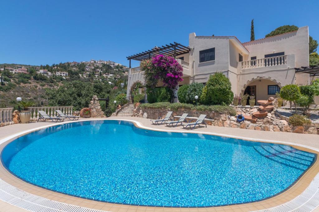 a large swimming pool in front of a house at Resitour - Kamares Village in Paphos