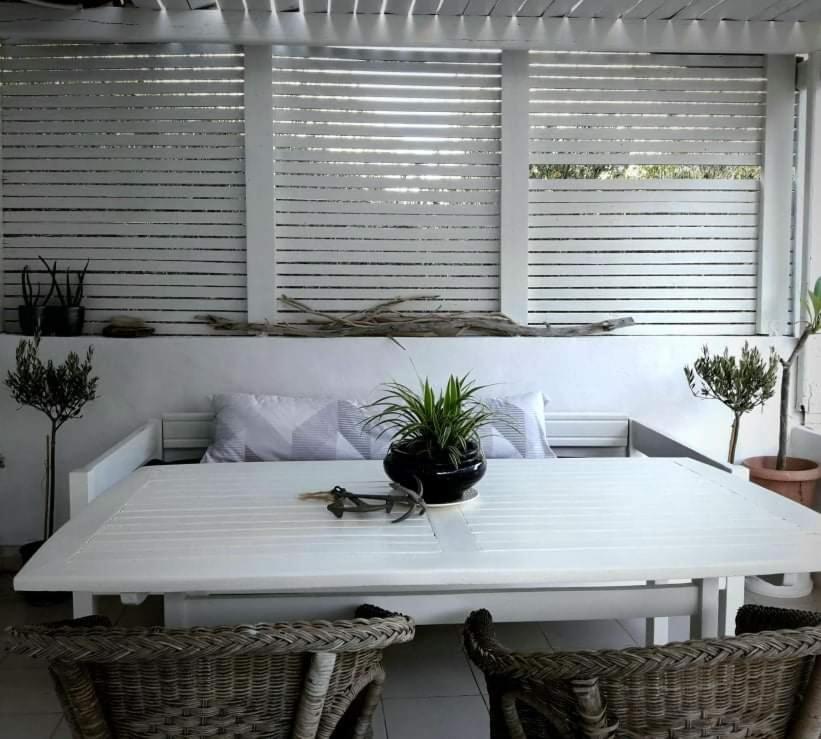 einem weißen Tisch mit einer Topfpflanze darüber in der Unterkunft On the beach in Koutsounári