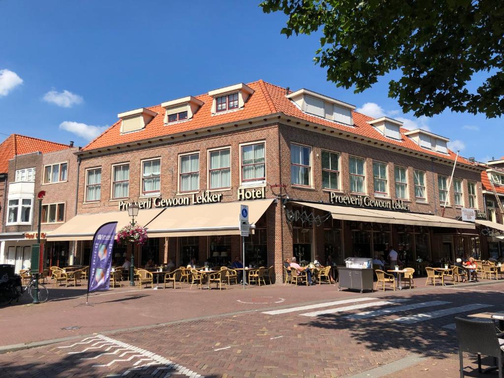 ein Gebäude in einer Straße mit Tischen und Stühlen in der Unterkunft Hotel de Keizerskroon Hoorn in Hoorn