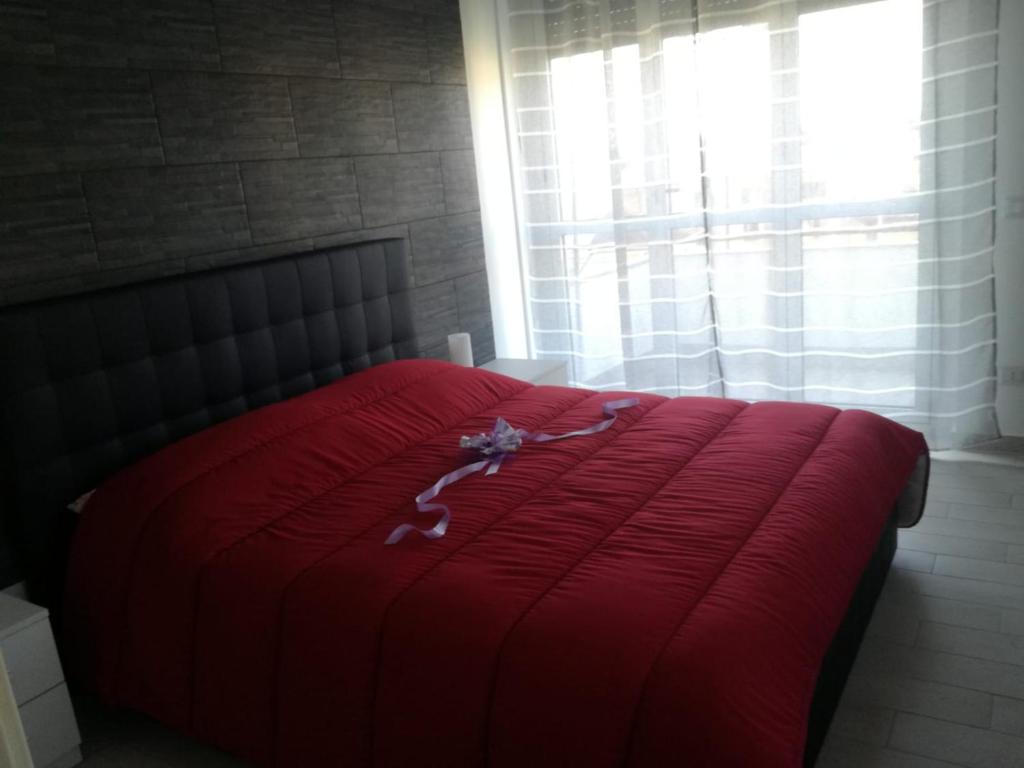 Cama roja en habitación con ventana en IL MELOGRANO HOLIDAY COMO, en Como