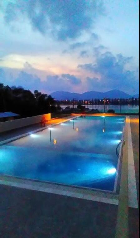 a large swimming pool with blue water at night at Marina Height Seaview Resort, Teluk Batik, Lumut in Kampong Tebing Rabak