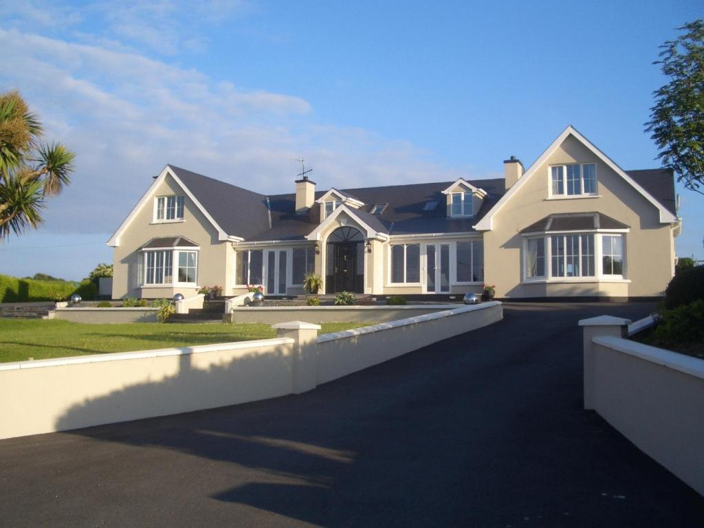 a large white house with a driveway at Rivermount House in Kinsale