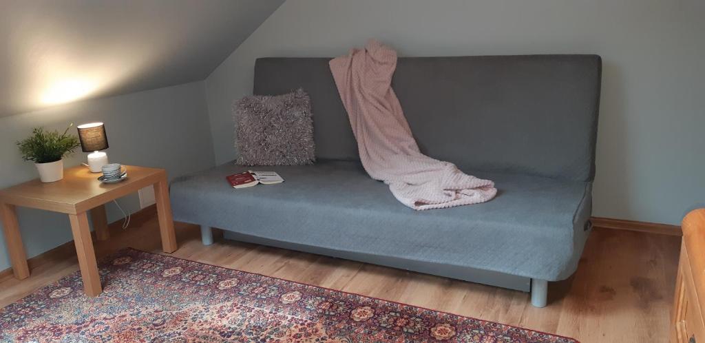 a couch with a blanket on it in a living room at Apartament w Oliwie in Gdańsk