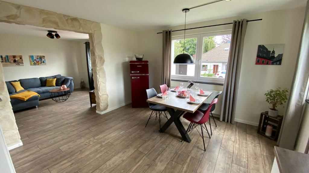 een woonkamer met een tafel en stoelen en een bank bij eifelbleibe in Monschau