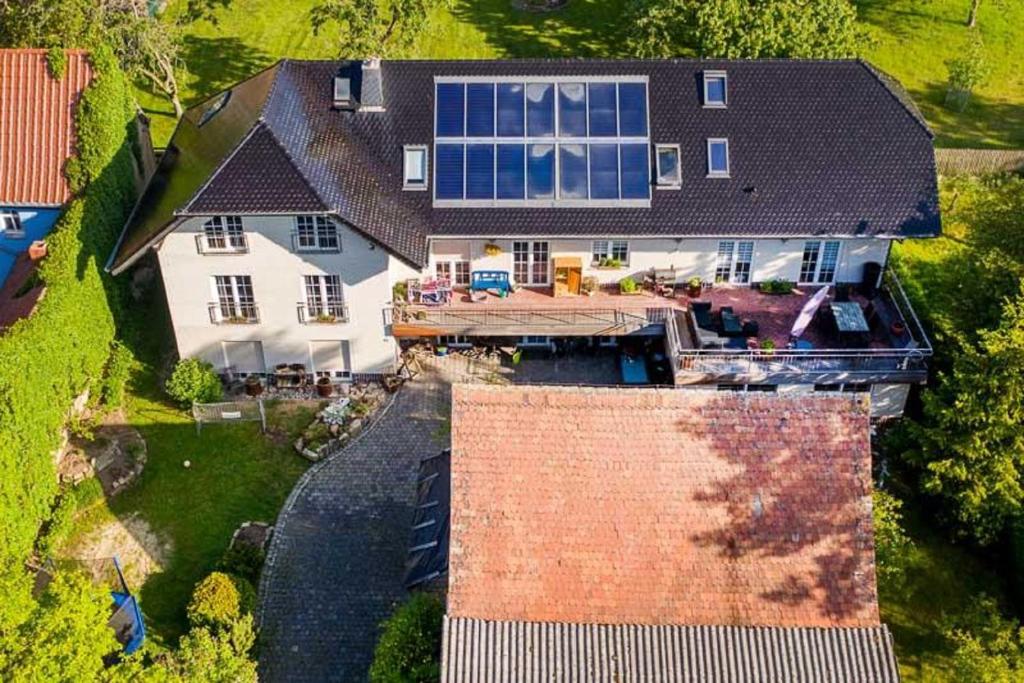an aerial view of a large house with a solar roof at Susis Ferienwohnungen in Braunsroda