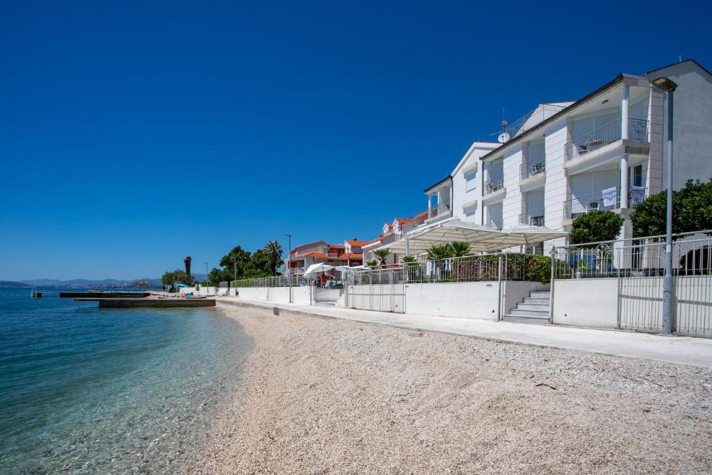 une rangée de maisons sur une plage au bord de l'eau dans l'établissement Hotel Neva, à Podstrana