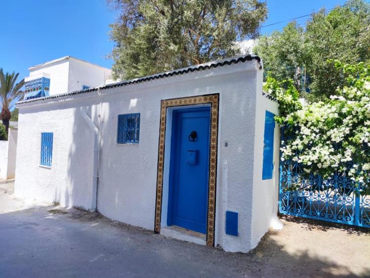 Maison à Sidi Bou Said في سيدي بو سعيد: مبنى ابيض عليه باب ازرق