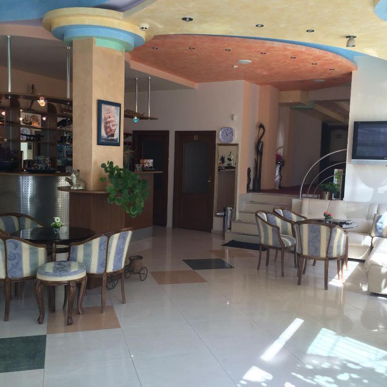 a dining room with tables and chairs in a building at Family hotel Dramchev in Nesebar