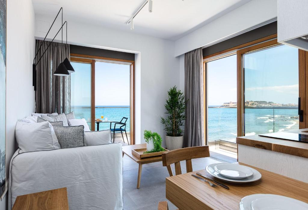 a living room with a bed and a view of the ocean at North Coast Seaside Suites in Rethymno Town