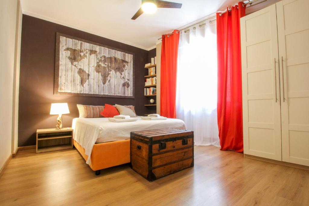 1 dormitorio con 1 cama y cortinas rojas en La maison du monde, en Bordighera
