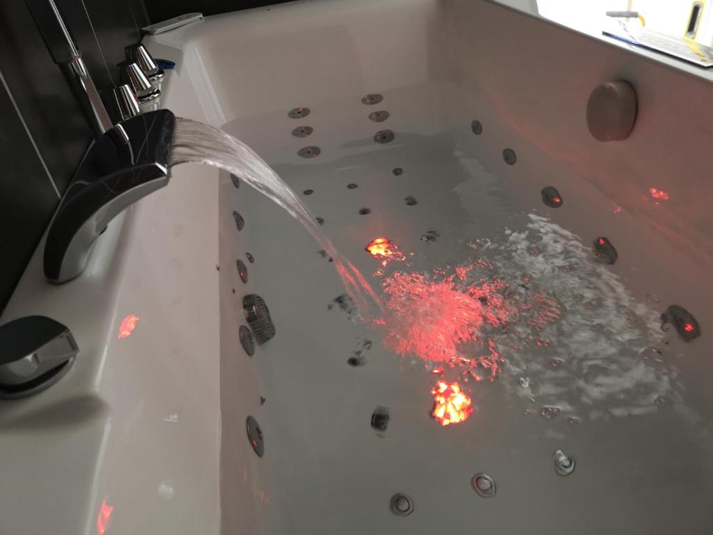 una bañera llena de agua con fuego. en Appartement moderne avec balnéothérapie, en Mers-les-Bains
