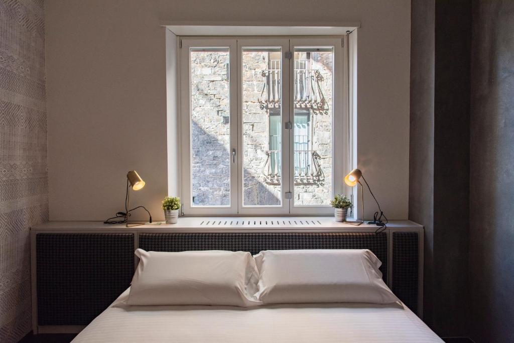sypialnia z łóżkiem i oknem w obiekcie PONTE VECCHIO LUXURY AND STYLISH APARTMENT we Florencji