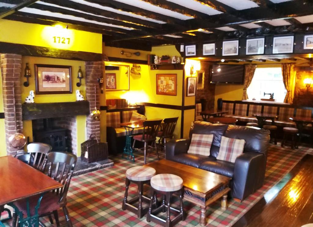 a living room with a couch and tables and a fireplace at The Tree House in Durham