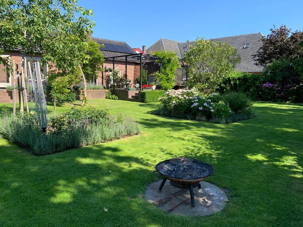 a garden with a fire pit in the grass at B&B 't Pakhuis in Meteren