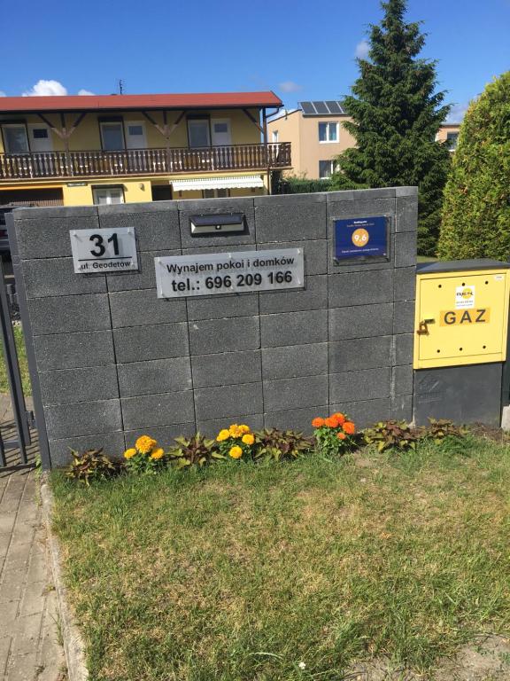 a concrete wall with signs on it in front of a building at Domki Letniskowe i pokoje Antonia in Władysławowo