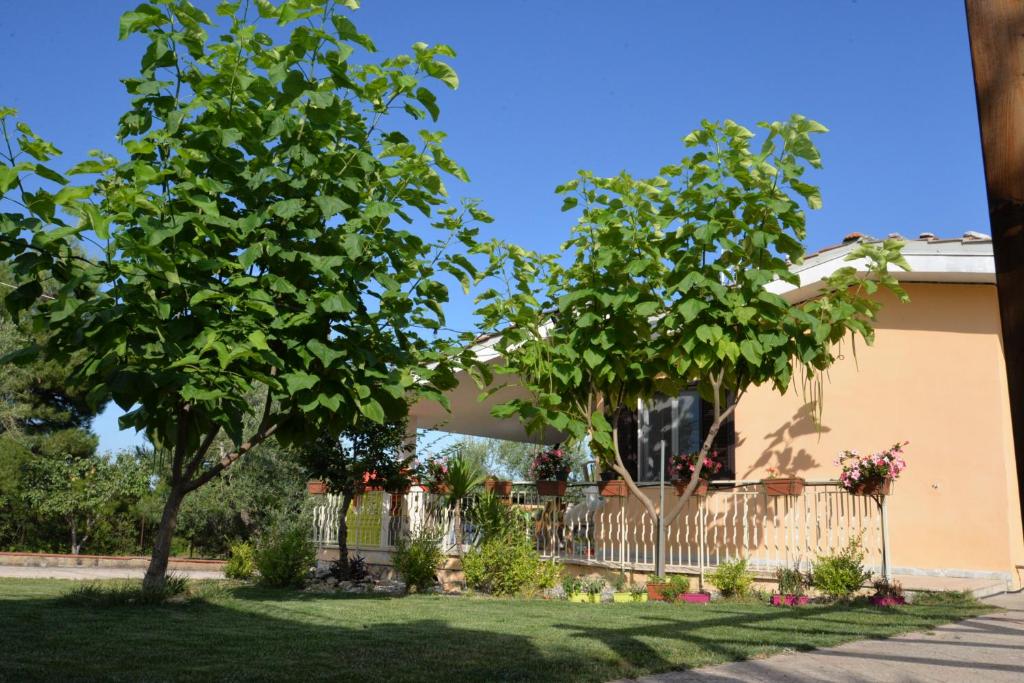 uma casa com uma cerca e uma árvore em B&B Lara Santola em Corato