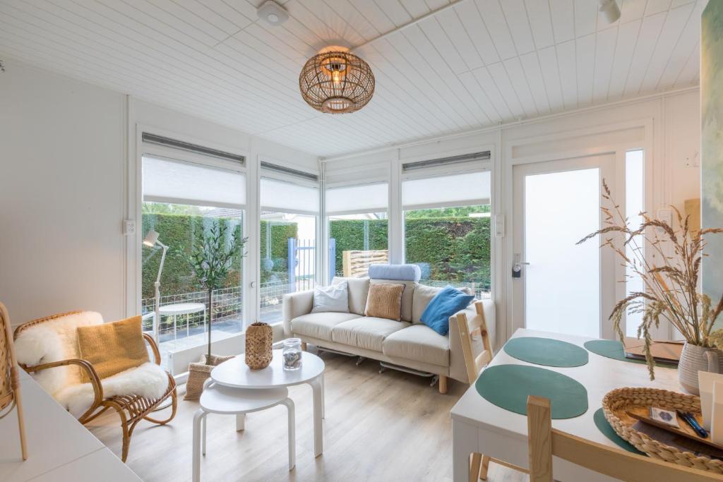 een woonkamer met een bank en een tafel bij Welcome in - Vakantiewoning met zonnige tuin, dichtbij zee en strand I Noordendolfer 2-49 in Zoutelande