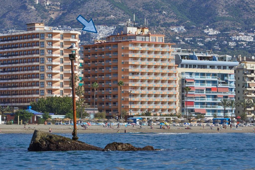 una cometa está volando sobre una playa con edificios en Apartamentos La Jabega, en Fuengirola