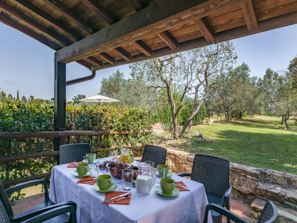 einen Tisch mit einem weißen Tischtuch auf einer Terrasse in der Unterkunft Villa Il Noce in Pergine Valdarno