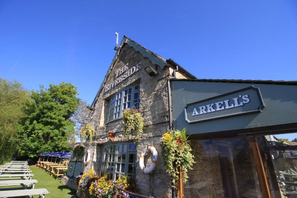 uma mulher a tirar uma fotografia a um edifício em The Riverside em Lechlade