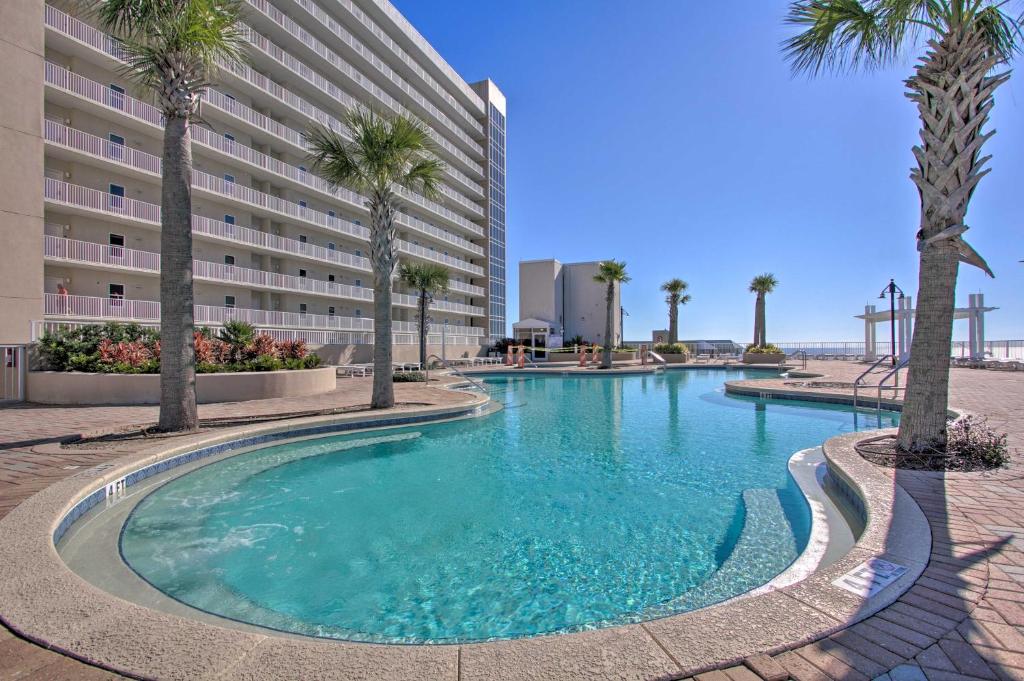 Una piscina con palmeras frente a un hotel. en Comfy PCB Condo with View and Private Beach Access!, en Panama City Beach