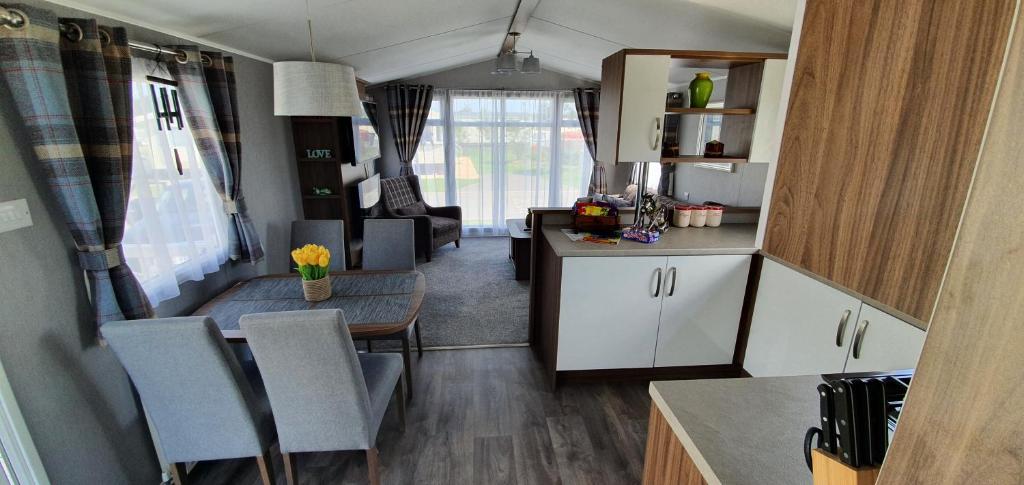 a kitchen and dining area of an rv at RJ Luxury Caravan Hire With Hot Tub in Tattershall