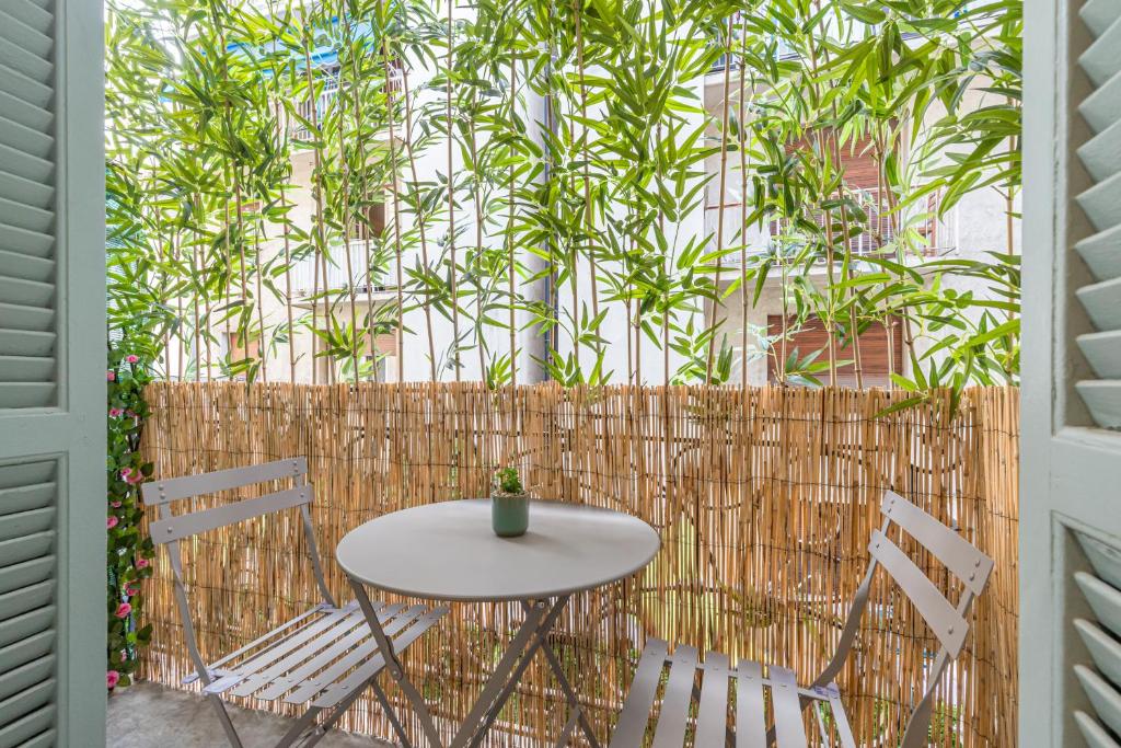 une table et des chaises sur une terrasse avec une clôture dans l'établissement HEROLD Balcon, à Nice