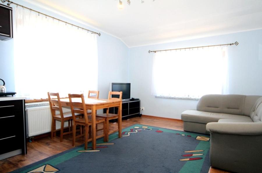 a living room with a table and a couch at Leniuchowo in Junoszyno
