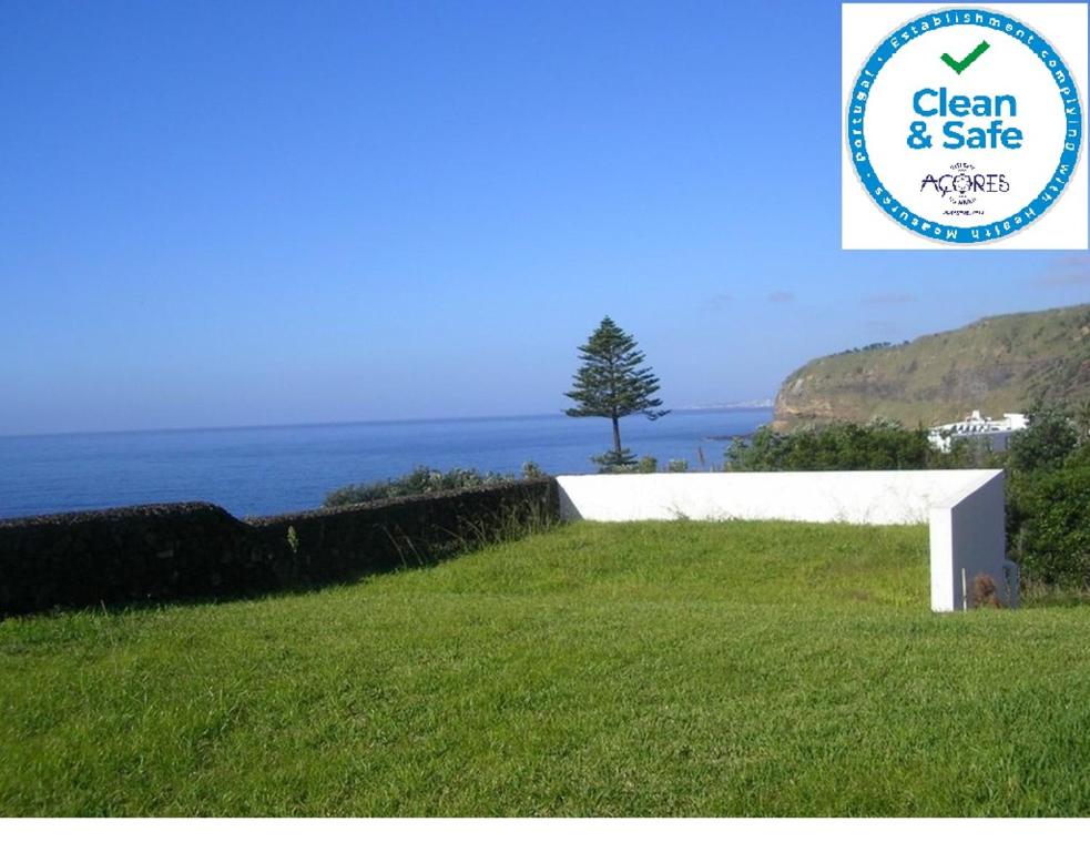 a sign that says clean and safe next to a field of grass at Vivenda Vista Mar 8 in Caloura