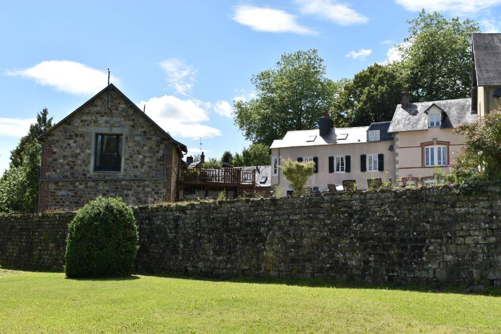 a stone wall in front of a house at Gites in Le Neufbourg -Mortain in Le Neufbourg