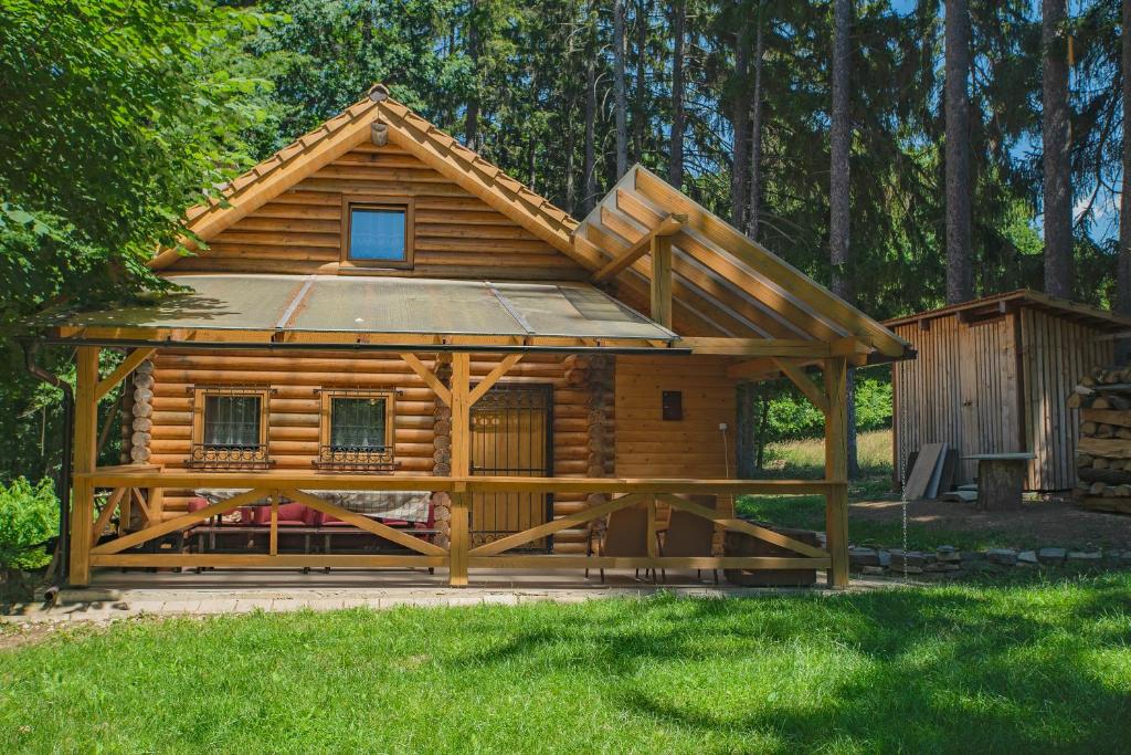 eine Blockhütte mit einer Veranda und einem Pavillon in der Unterkunft Chata Hlboké in Bojnice