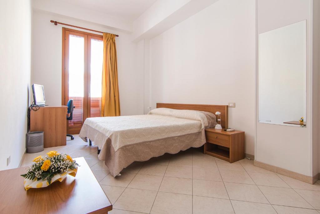 - une chambre avec un lit et une table fleurie dans l'établissement Galatea appartamento grande, à Pozzallo