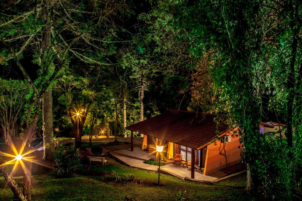 a house in the middle of a forest at night at Verona Parque Hotel in Veranópolis