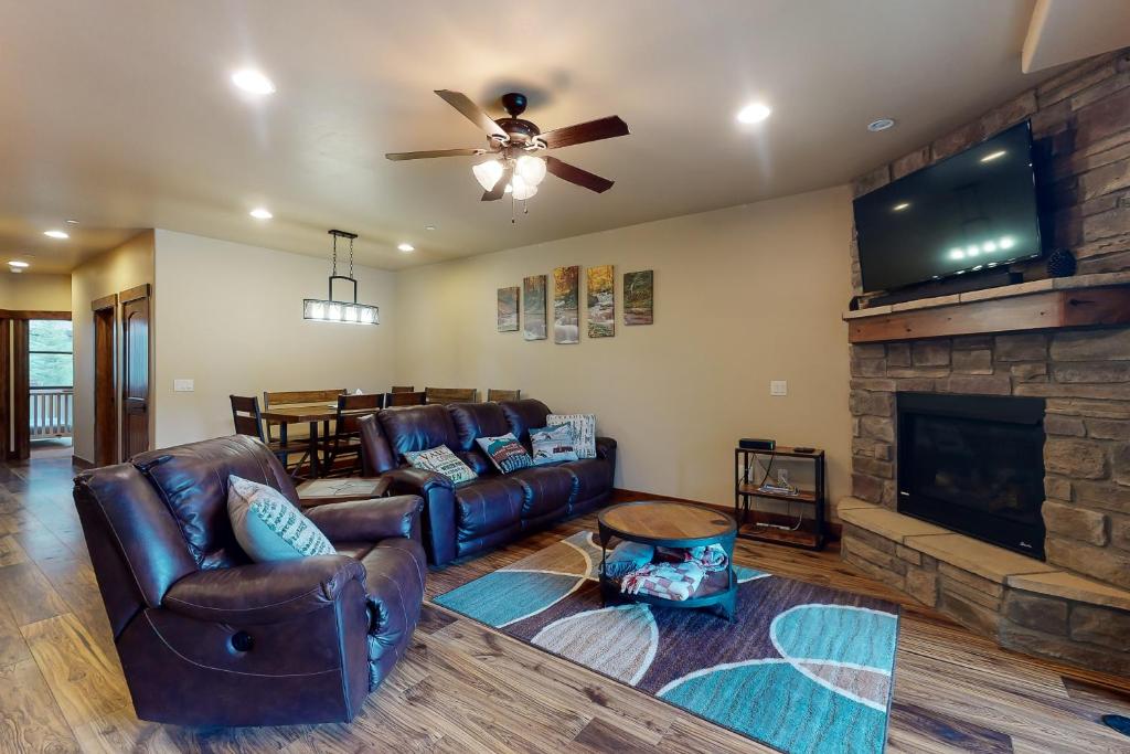 a living room with leather furniture and a fireplace at Riverfront Retreat & River's Edge Townhome in Silverthorne