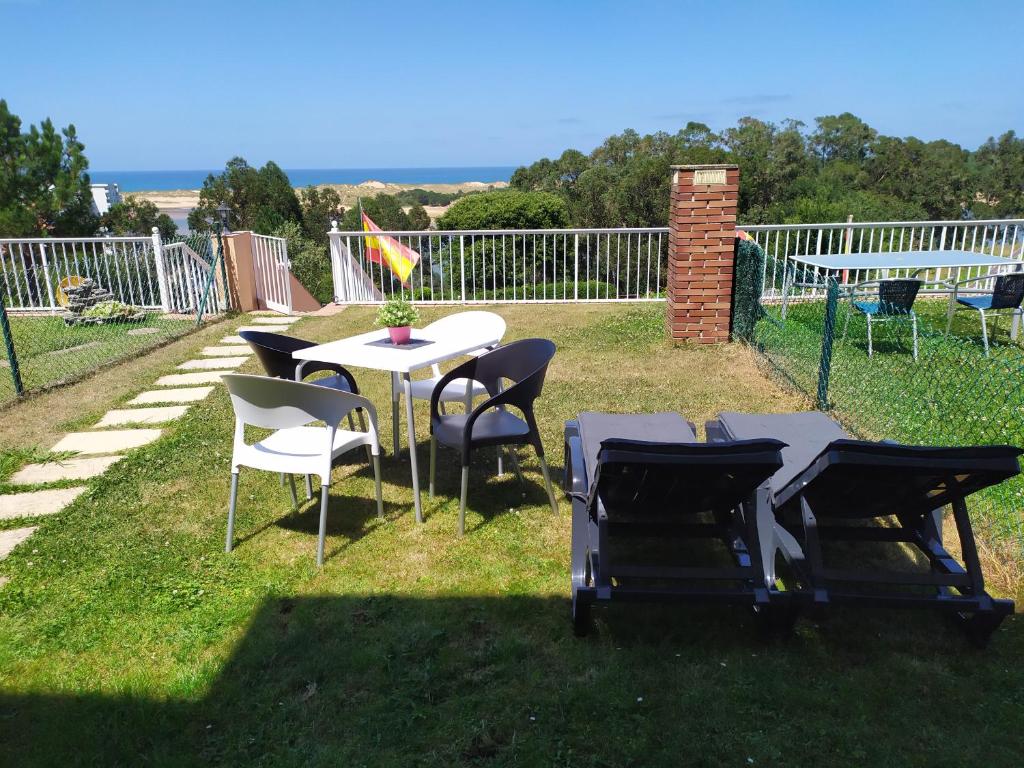 a group of tables and chairs in the grass at Apartamento con jardin privado junto playa Usil - Mogro in Miengo