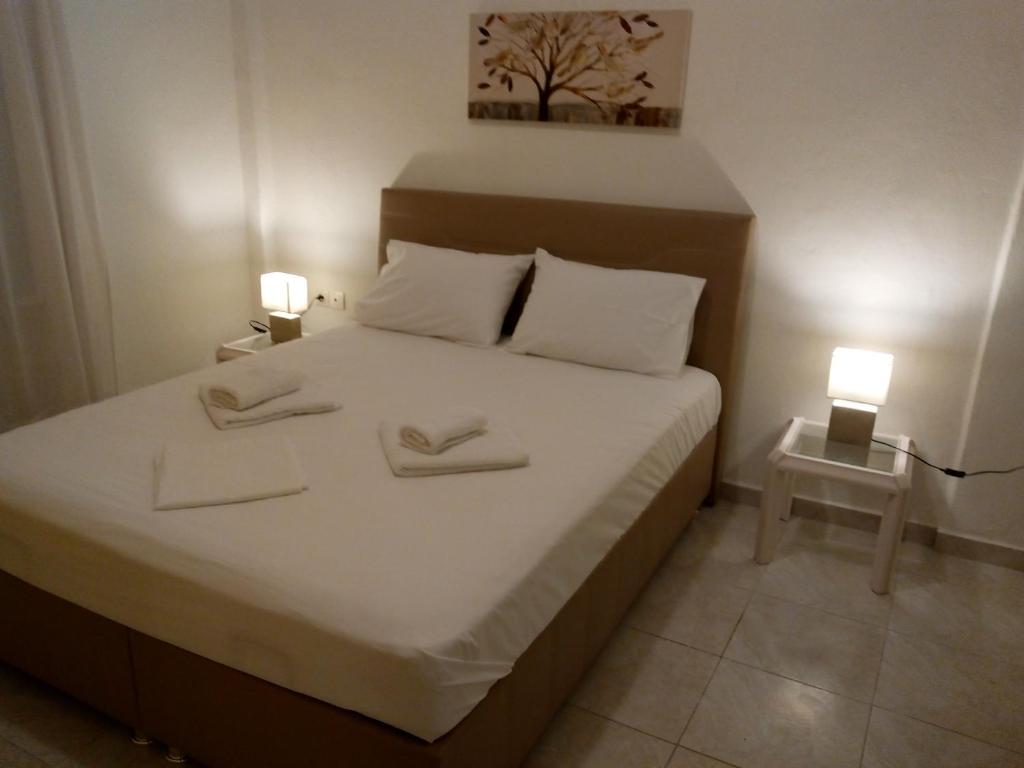 a bedroom with a white bed with two towels on it at Maza House in Stavros
