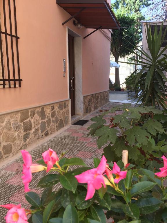 a garden with pink flowers in front of a building at STELLA appartamento in Policoro