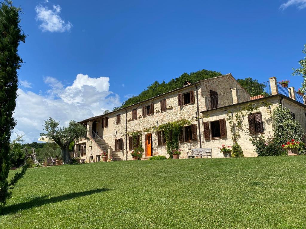 una antigua casa de piedra con un gran patio en Casa delle Sorgenti, en Montefiore dellʼAso