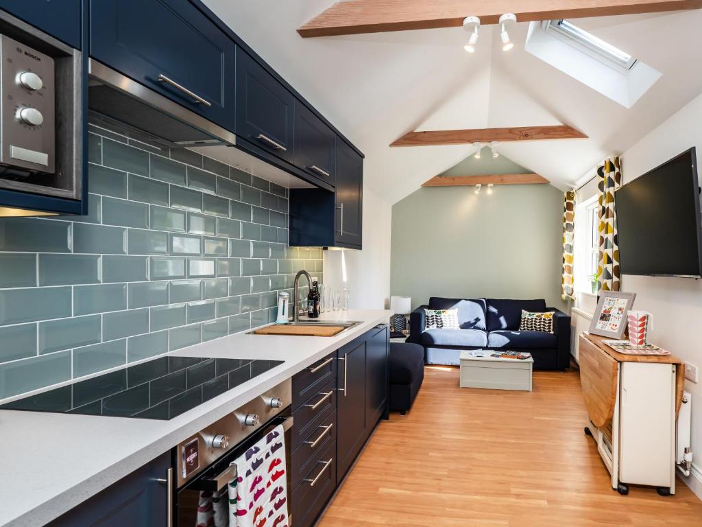 uma cozinha com armários pretos e azulejos azuis em Horatio’s em Worstead