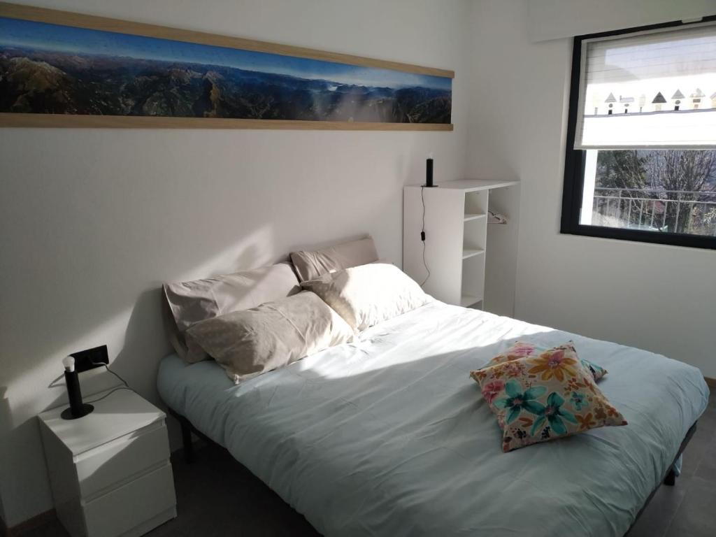 a white bedroom with a bed with a window at Mountain Holidays B&B in Rovetta