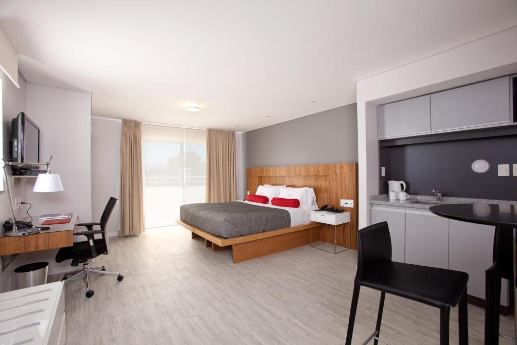 ein Hotelzimmer mit einem Bett, einem Schreibtisch und einem Stuhl in der Unterkunft Rambla Apartamentos in Montevideo