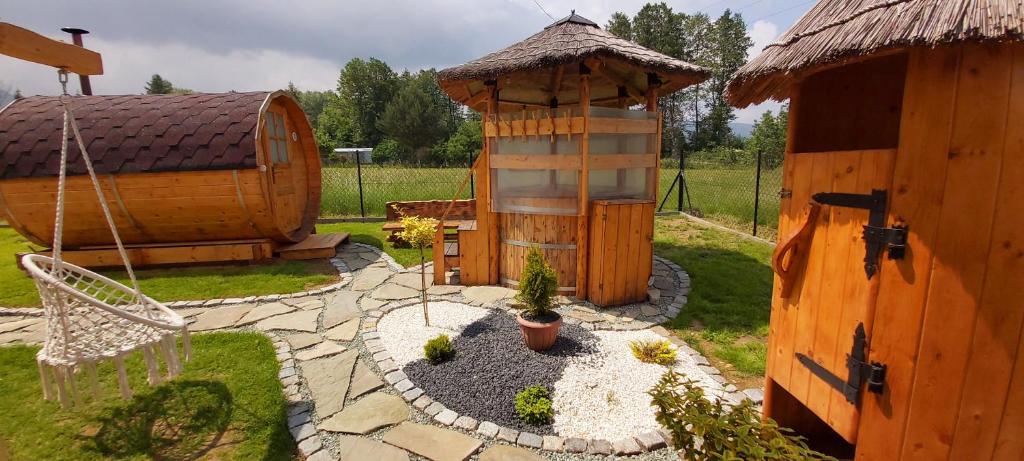 un patio trasero con una casa de madera y un jardín en Rafi House Relax i Spa dom koło Szczyrku en Szczyrk