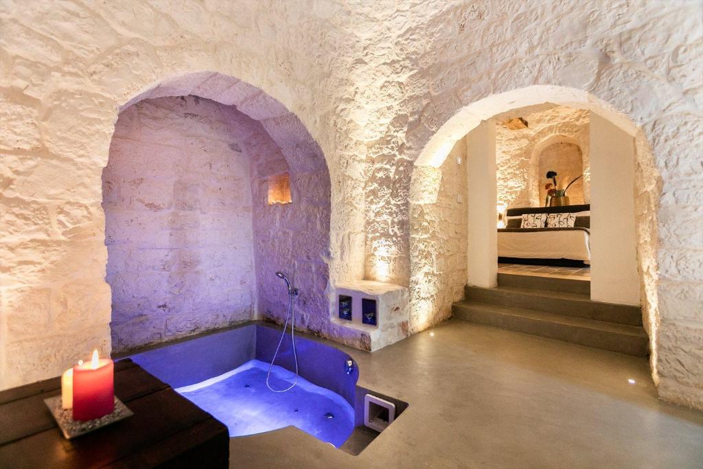 un baño en el medio de una habitación con una vela en DIMORA RITUNNO, en Locorotondo