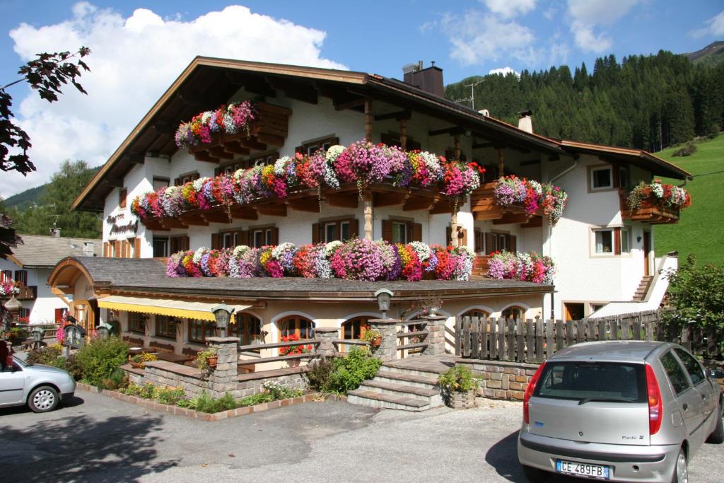 a building with lots of flowers on it at Hotel Mooserhof in Sesto